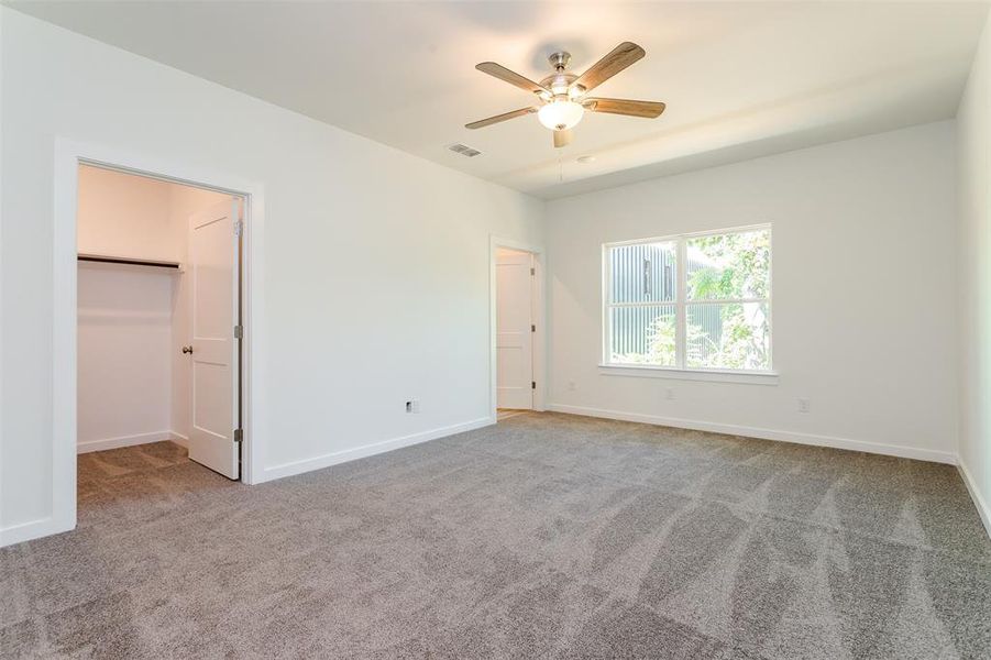 Carpeted spare room with ceiling fan