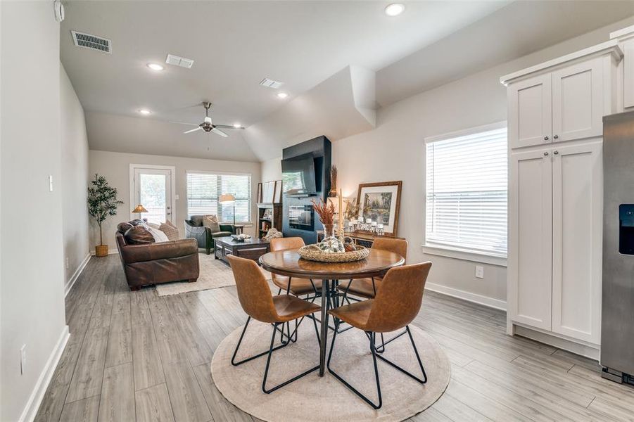 Dining area with light wood-type flooring, lofted ceiling, and ceiling fan