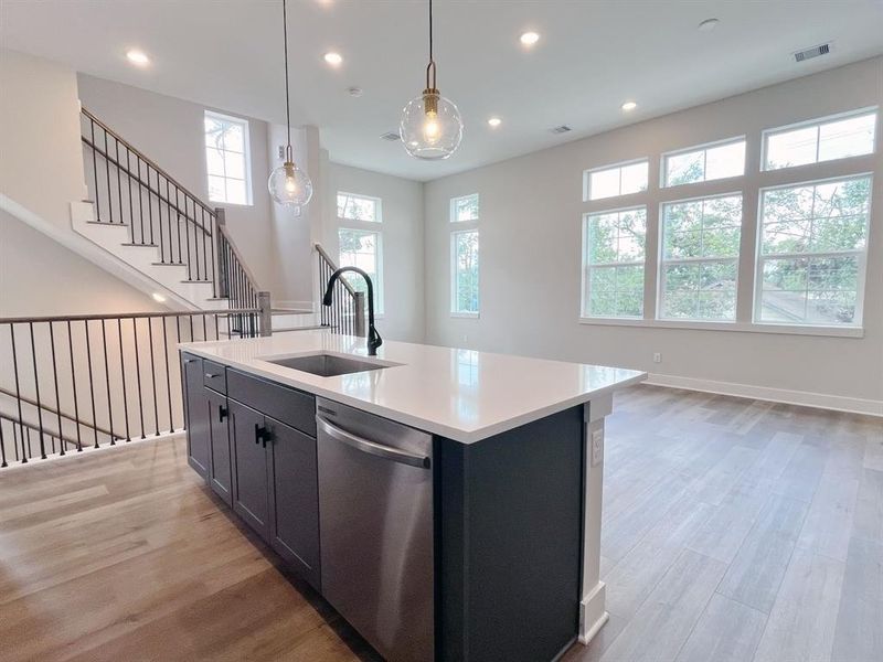 Elegant Centerpiece Island: A spacious, modern kitchen island with sleek countertops and ample storage, bathed in natural light from surrounding windows, perfect for entertaining and culinary creations.