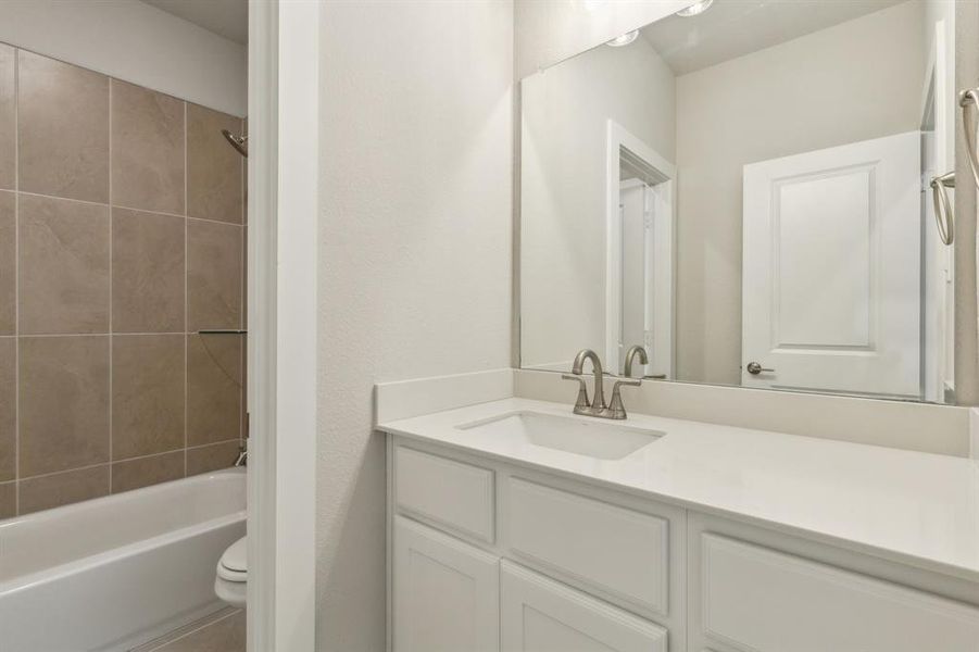 Full bathroom with vanity, toilet, and tiled shower / bath