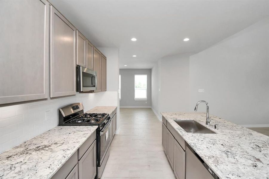 Discover another perspective of this stunning kitchen, generously appointed with an abundance of counter space. Sample photo of completed home with similar floor plan. Actual colors and selections may vary.