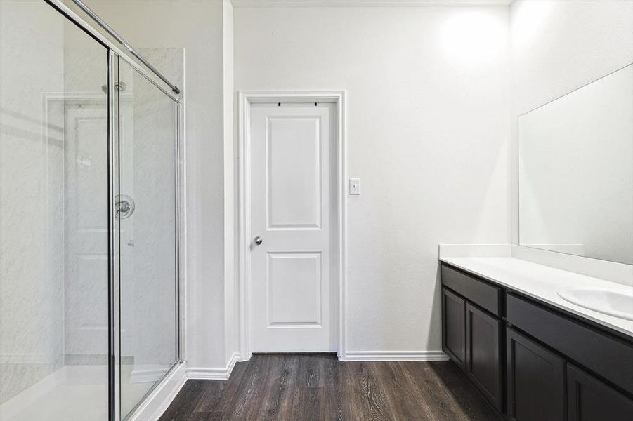 Bathroom with hardwood / wood-style flooring, walk in shower, and vanity