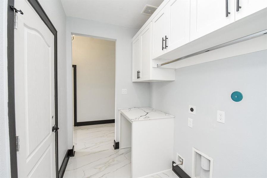The utility room inside the home is spacious, with storage cabinets and plenty of space.