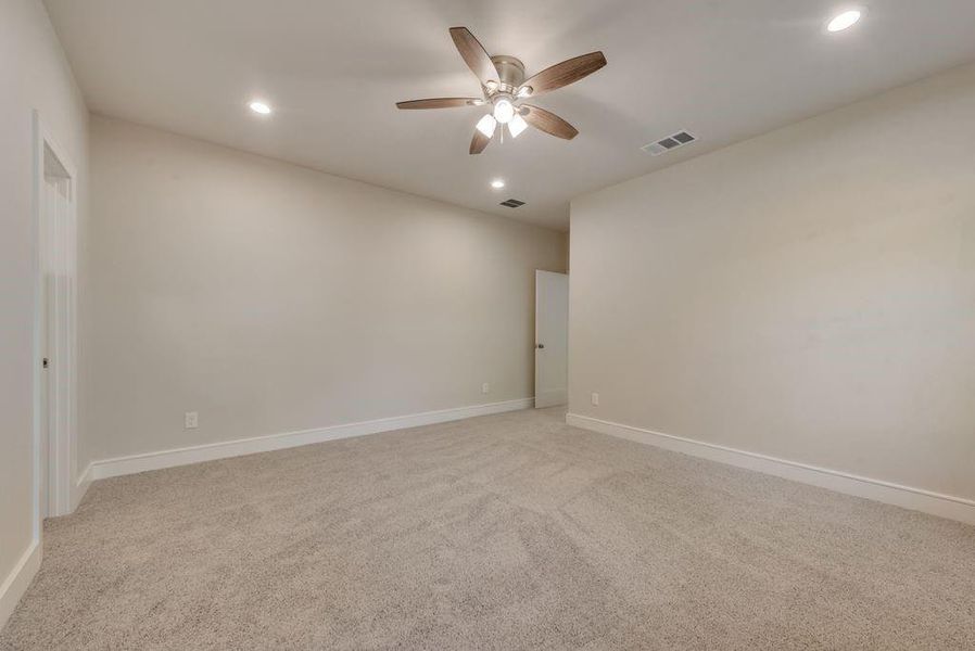 Carpeted spare room with ceiling fan