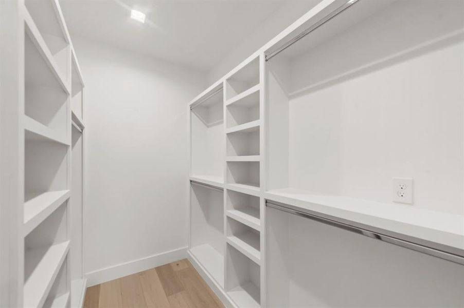 Spacious closet with light hardwood / wood-style floors