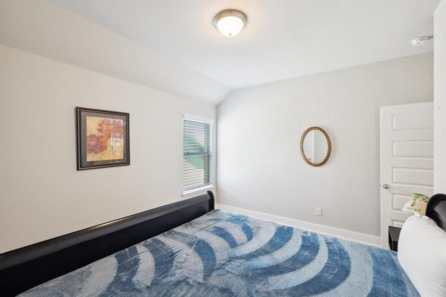 Bedroom featuring lofted ceiling and carpet flooring