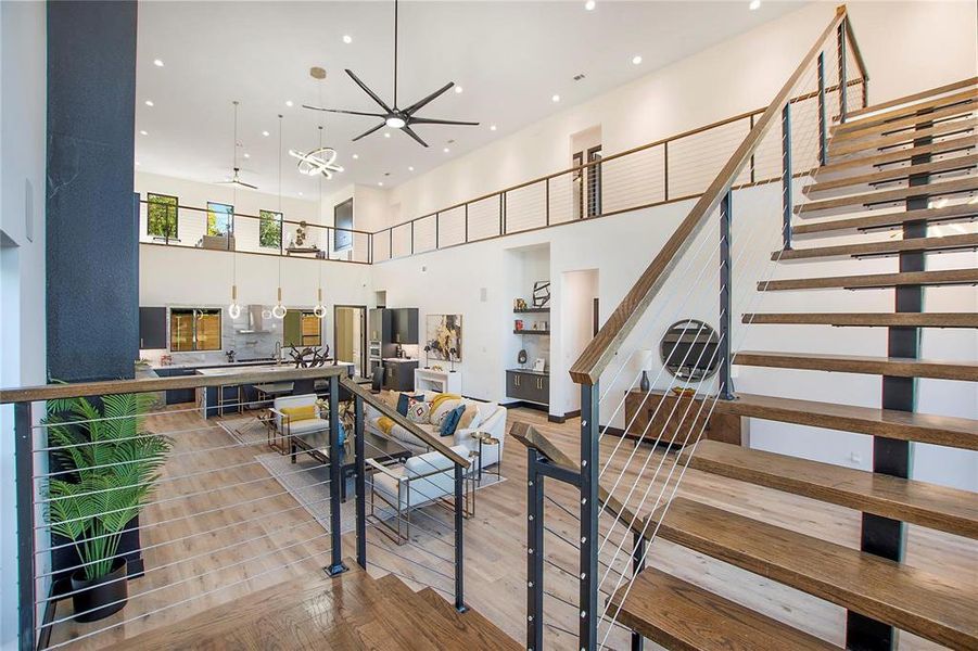 Staircase featuring a high ceiling, light hardwood / wood-style flooring, and ceiling fan