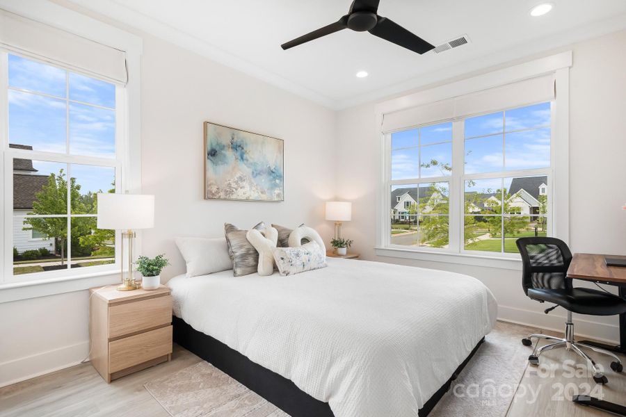 Main level bedroom with tons of nautral light.  Featuring a ceiling fan, wood floors, walk in closet and ensuite bath.