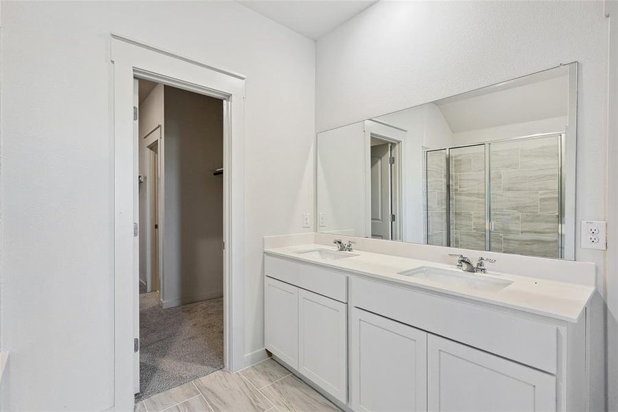 Bathroom with vanity and a shower with door