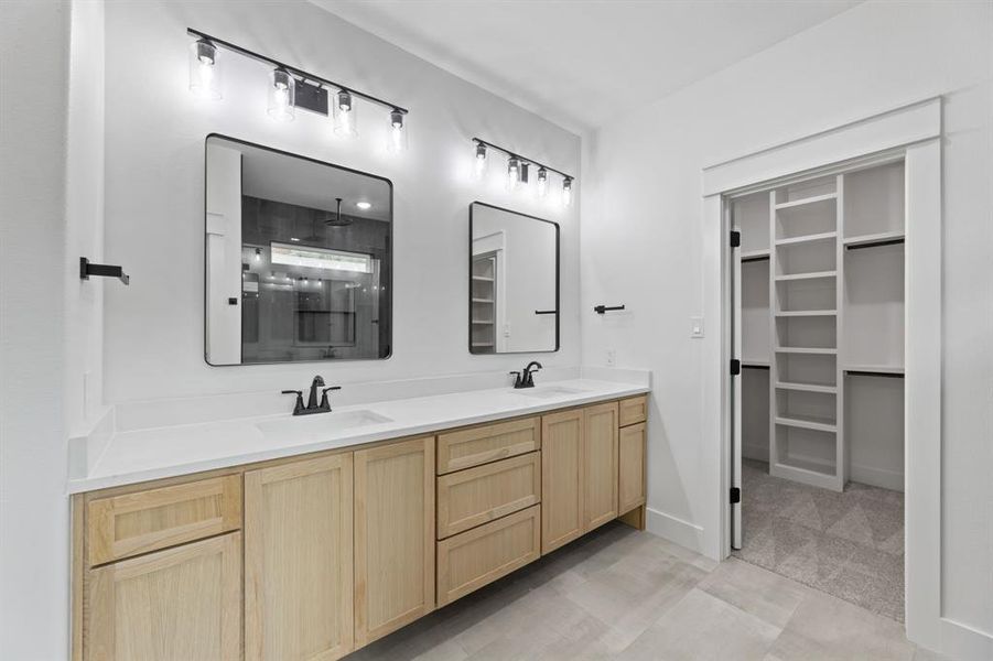 master bathroom with tile floors, large vanity, and double sink