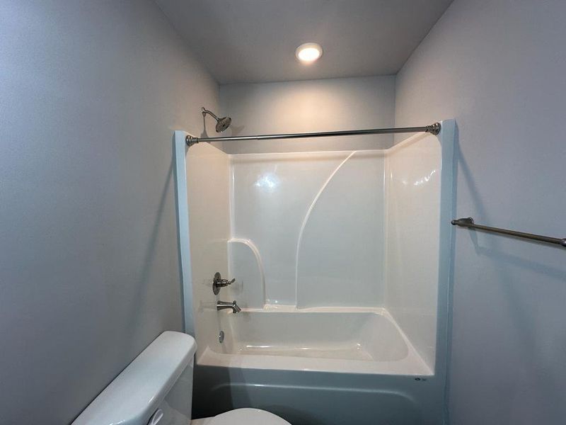 Bathroom with toilet and bathing tub / shower combination