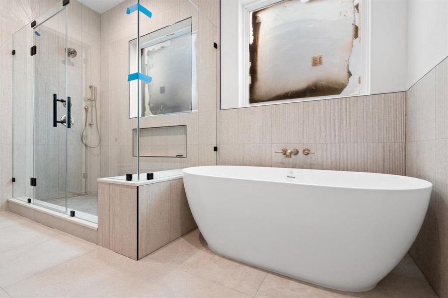 Primary bathroom with separate tub and walk in shower.