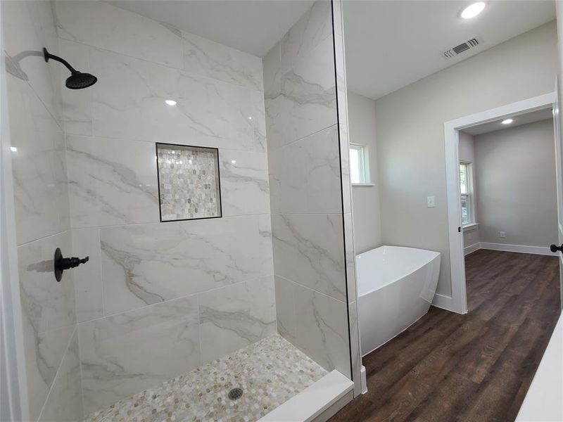 Primary Bathroom featuring wood-type flooring and shower with separate bathtub