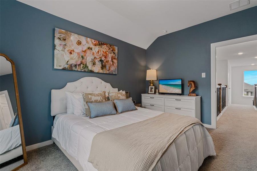 Carpeted bedroom featuring lofted ceiling