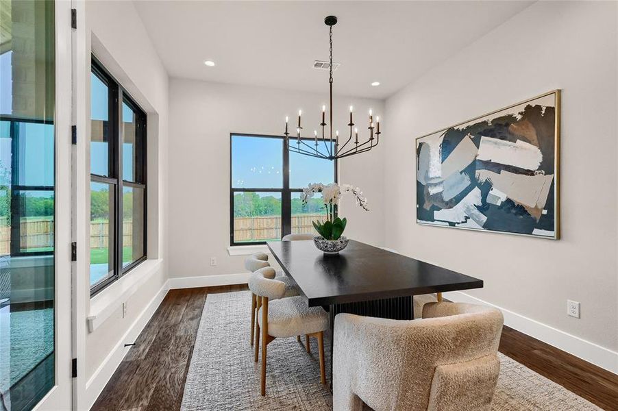 Dining space with an inviting chandelier and wood floors