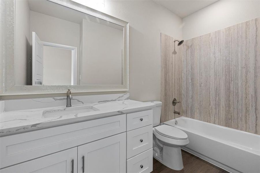 Full bathroom with vanity, shower / bath combination, toilet, and hardwood / wood-style floors