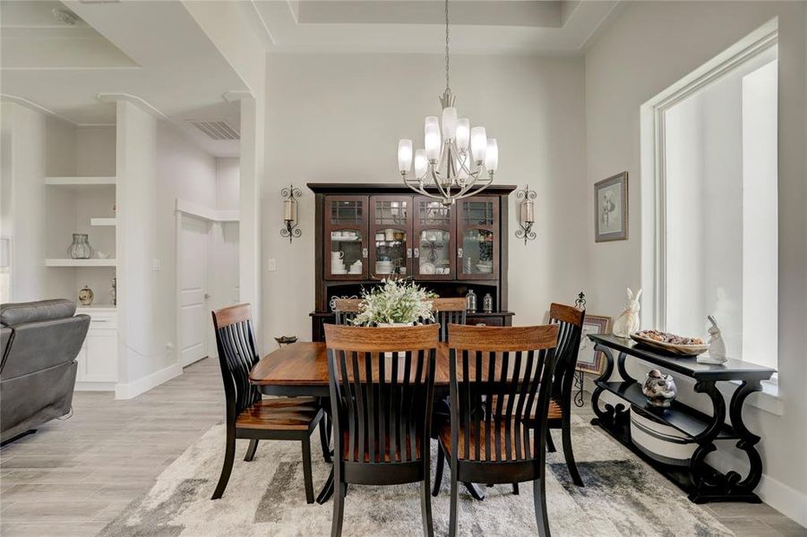 ENJOY FAMILY MEALS AND HOST ELEGANT DINNERS IN THIS SOPHISTICATED DINING ROOM, WHICH FEATURES MODERN LIGHTING FIXTURES AND A WARM, INVITING AMBIANCE PERFECT FOR CREATING MEMORABLE MOMENTS.