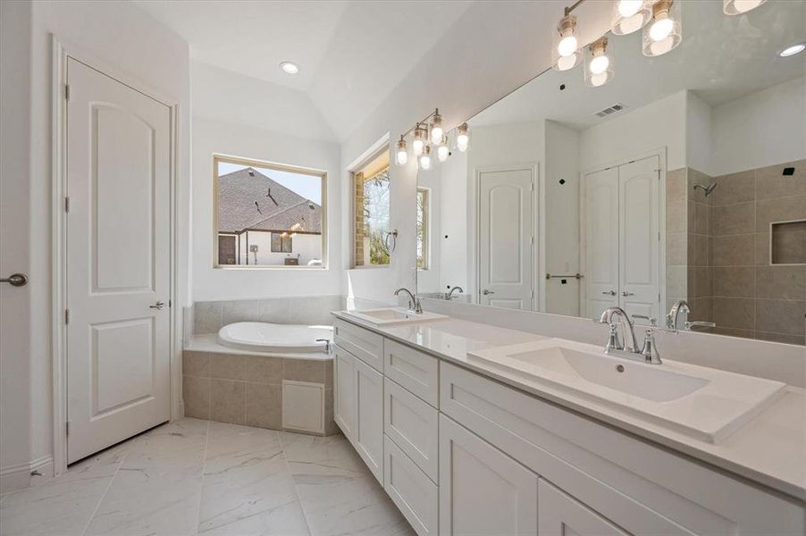 Bathroom with vanity, independent shower and bath, and lofted ceiling