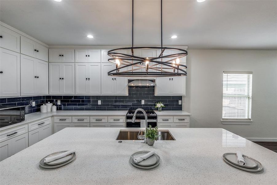 Kitchen featuring white cabinetry, tasteful backsplash, and pendant lighting