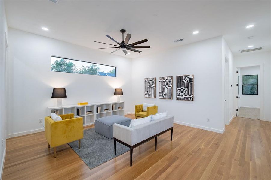 Living room with light wood-type flooring and ceiling fan