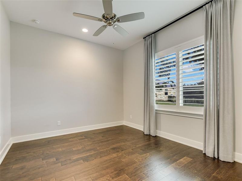 primary bedroom with remote control curtains, and plantation shutters