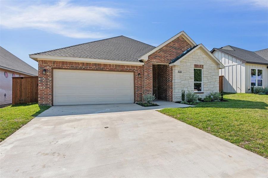 Ranch-style home featuring a front yard and a garage