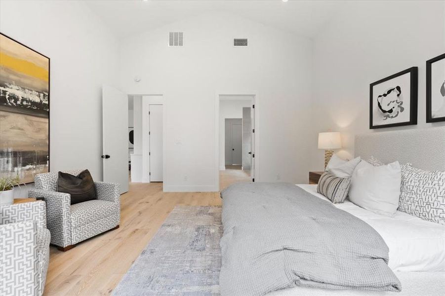 Bedroom with high vaulted ceiling and light hardwood / wood-style floors