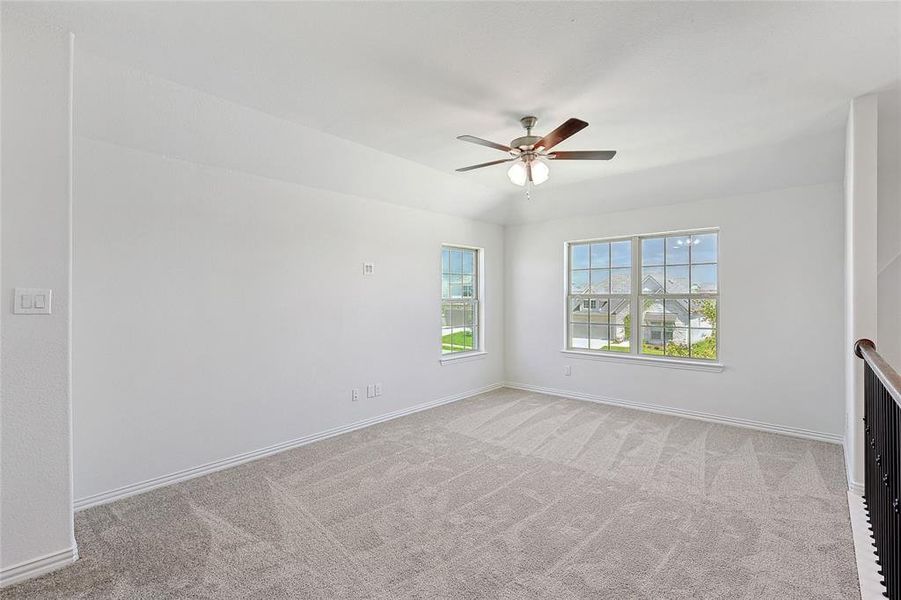 Carpeted empty room with ceiling fan