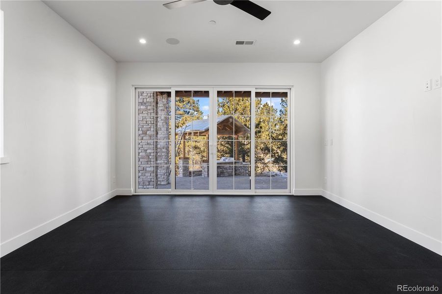 Home Gym/Exercise Room with doors to lower patio
