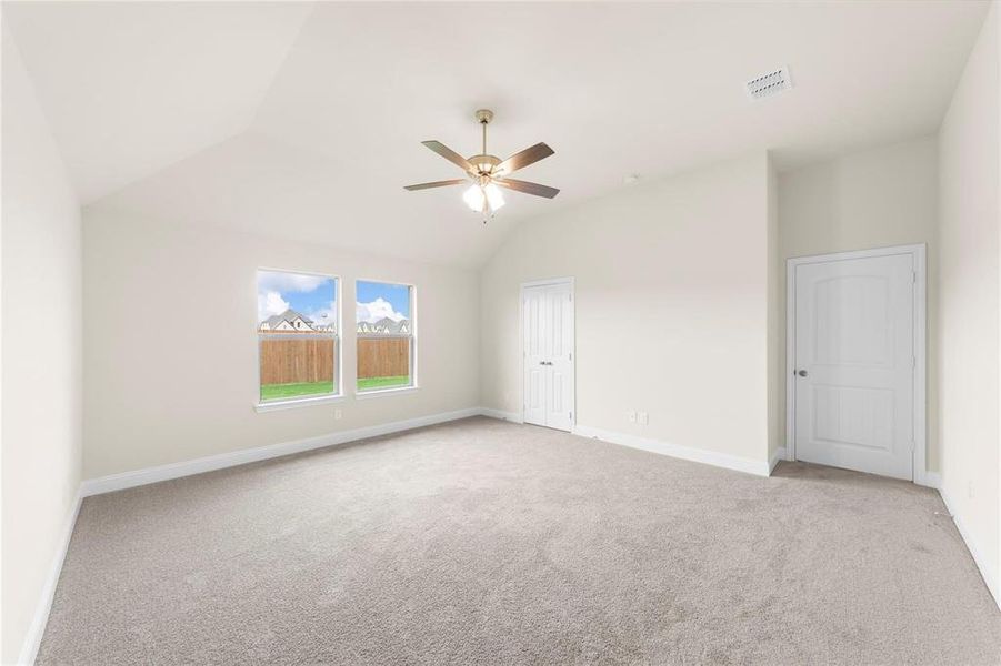 Carpeted spare room with lofted ceiling and ceiling fan