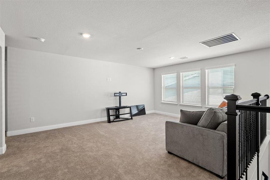 Living room with light carpet and a textured ceiling