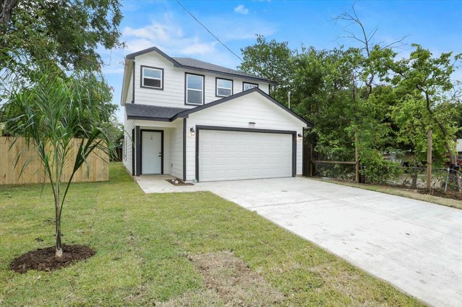 View of front of property featuring a garage and a front yard