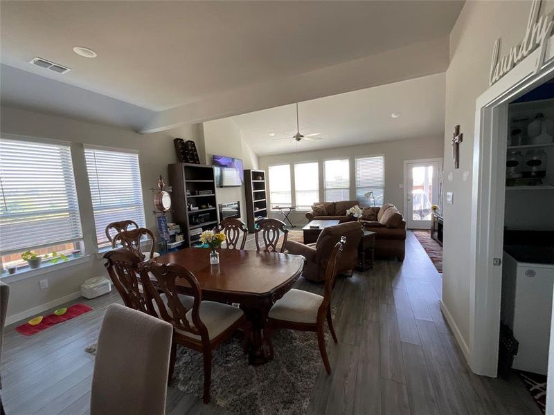 Dining area with vaulted ceiling, ceiling fan, and dark wood-type flooring