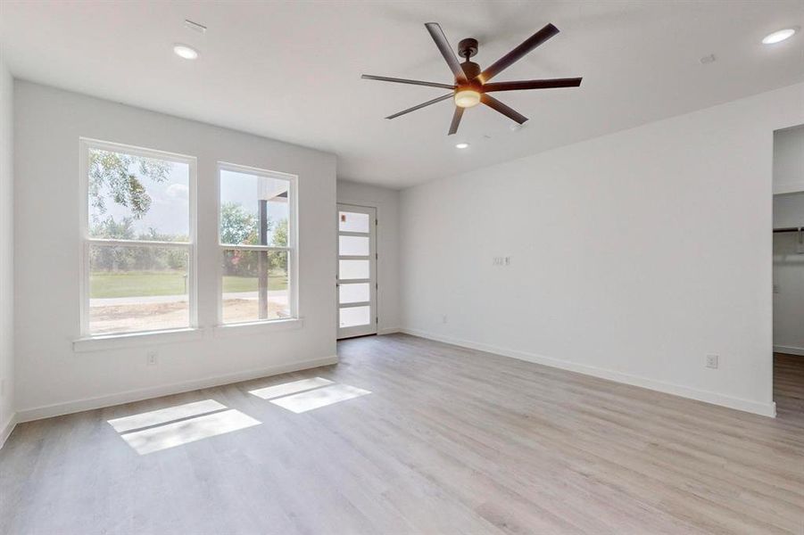 Spare room with light hardwood / wood-style flooring, a healthy amount of sunlight, and ceiling fan