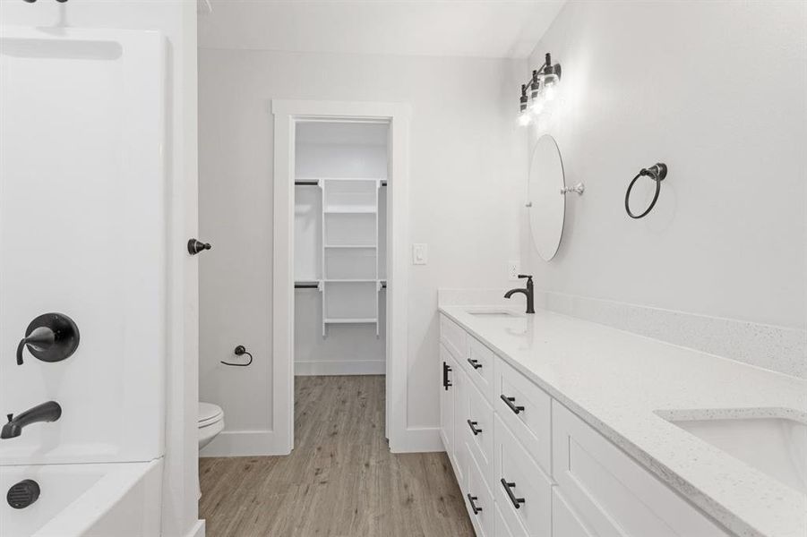 Full bathroom featuring separate shower and tub, vanity, toilet, and hardwood / wood-style flooring