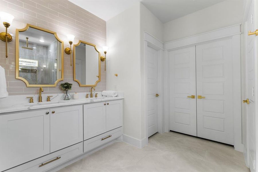 Bathroom with tile walls, vanity, a shower, and tasteful backsplash