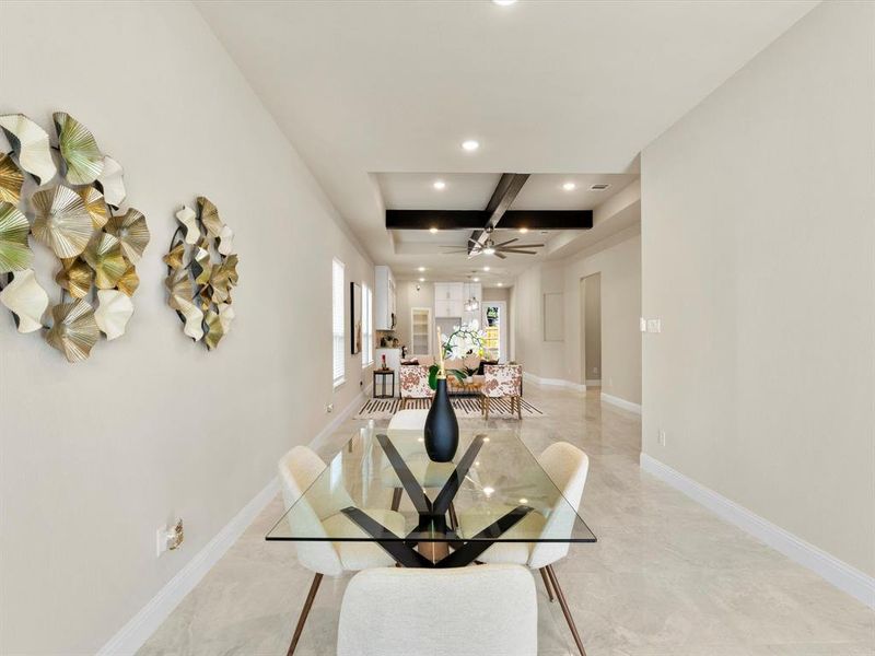 Dining space with ceiling fan, beamed ceiling, and coffered ceiling