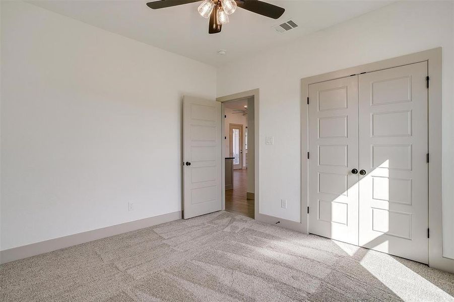 Unfurnished bedroom with light colored carpet, a closet, and ceiling fan