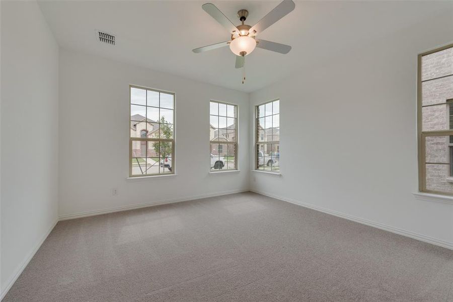 Carpeted empty room featuring ceiling fan