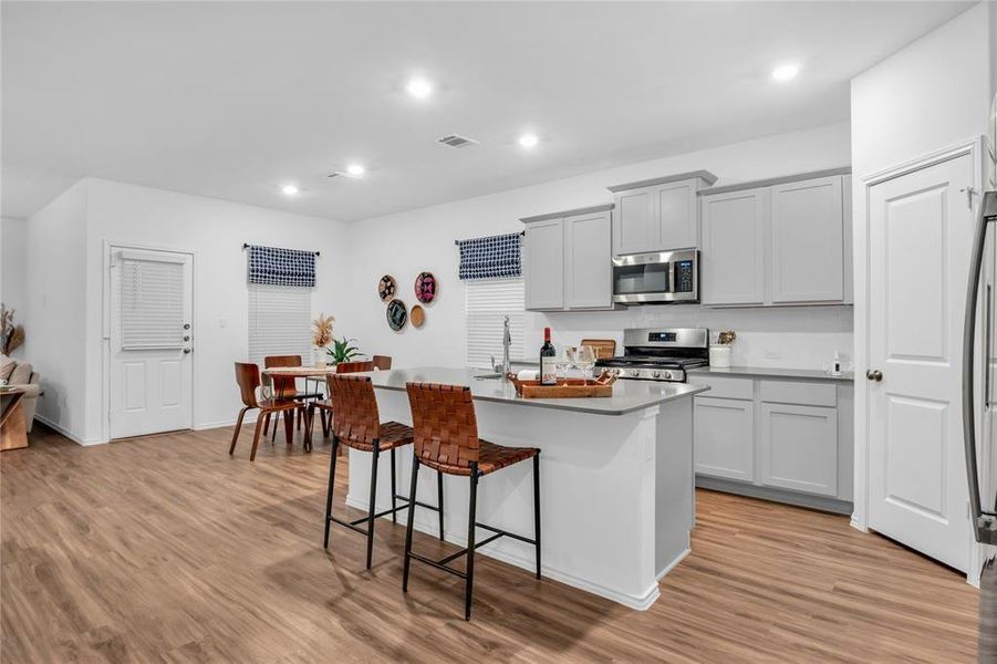 Beautiful grey shaker cabinets & kitchen island with grey quartz countertops