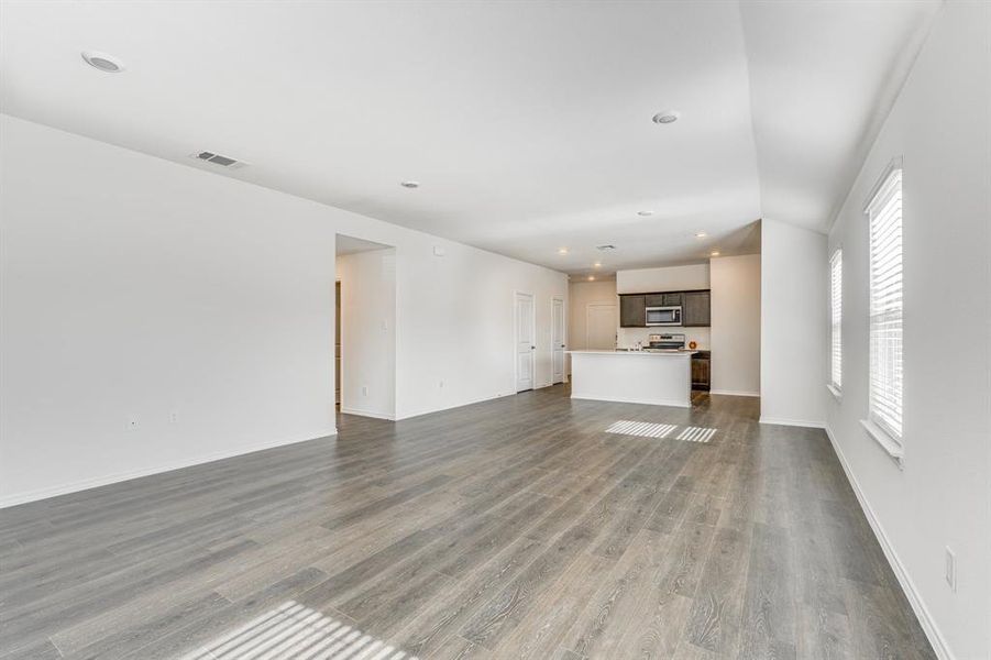 Unfurnished living room with hardwood / wood-style floors and a healthy amount of sunlight