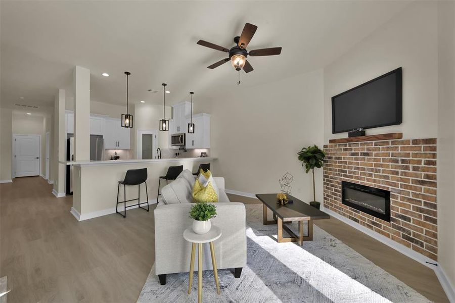 This living room is adjacent to the kitchen. The breakfast bar is well lit and provides additional seating.