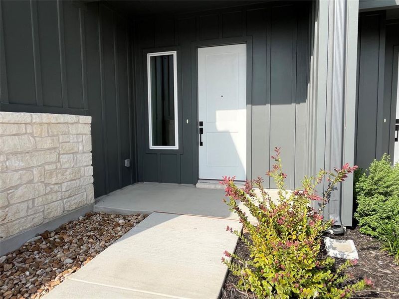 Front covered entrance with an 8' front door and modern sidelite window