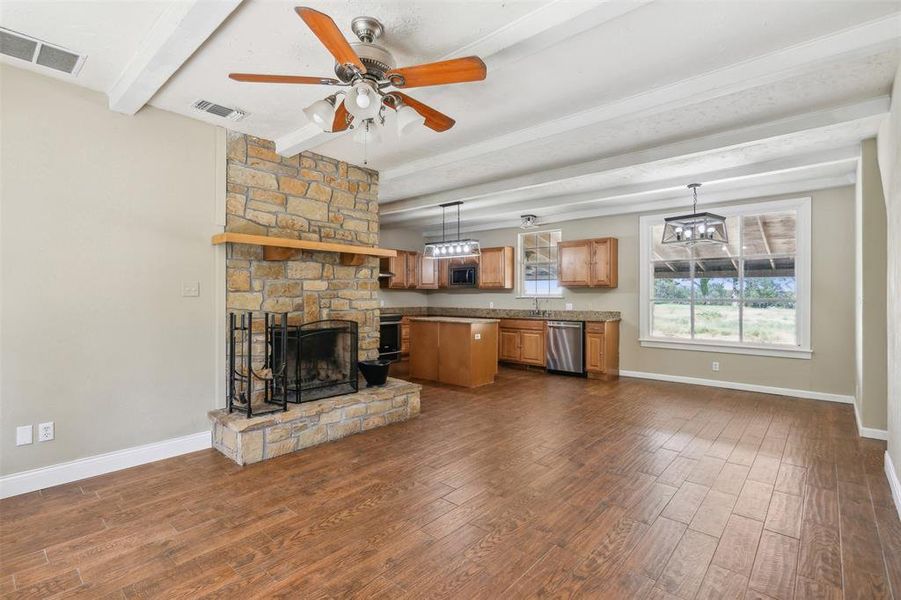 Family room featuring a fireplace, hardwood / wood-style flooring, ceiling fan, and beam ceiling