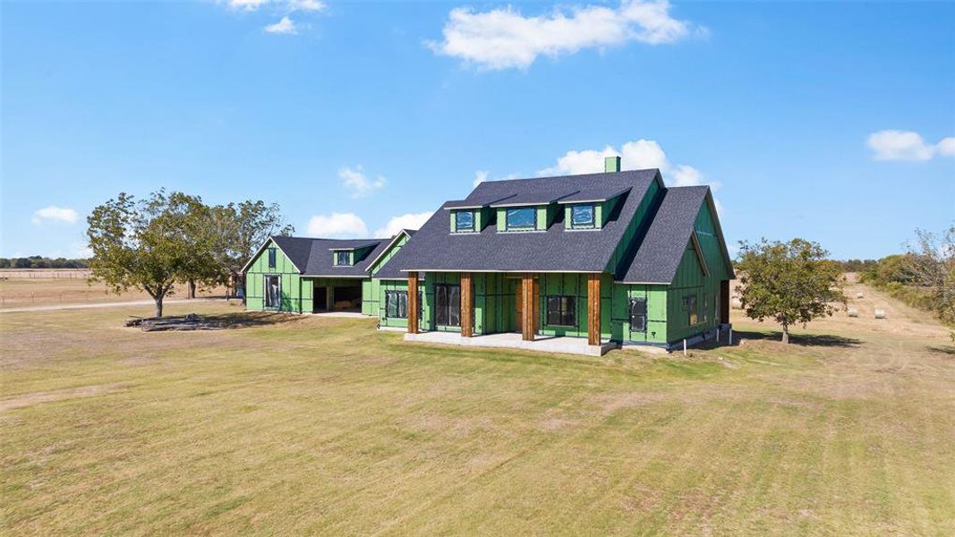 Back of house with a lawn and a porch