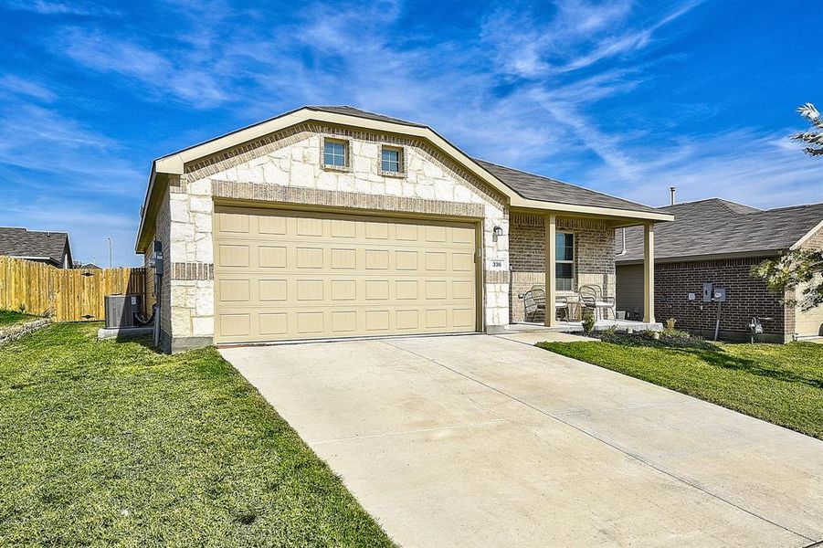 Ranch-style home with a garage, central air condition unit, and a front lawn