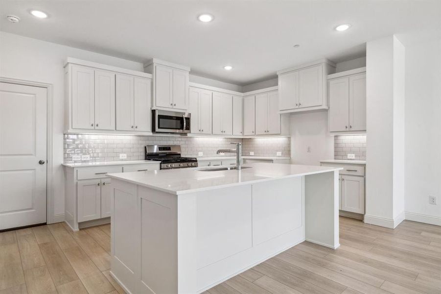 Crisp, clean whites, beautiful flooring and stainless appliances...who wouldn't love this over the top kitchen?