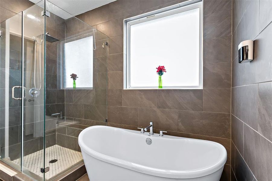 The primary bath also comes with a frameless glass walk-in shower with rain head as well as the stand alone soaking tub.