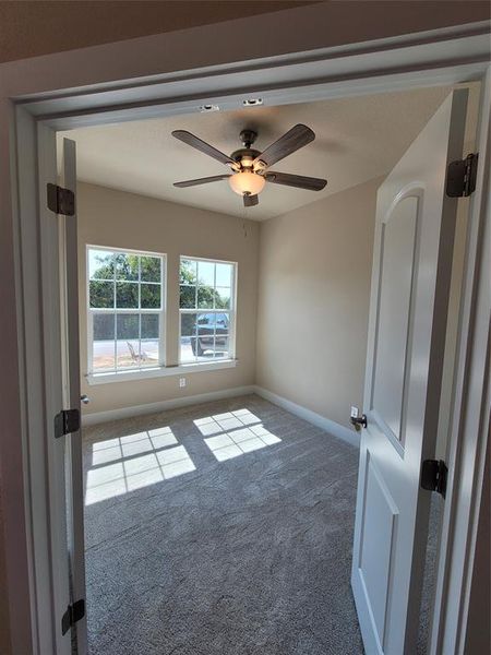 Unfurnished room with ceiling fan and carpet flooring