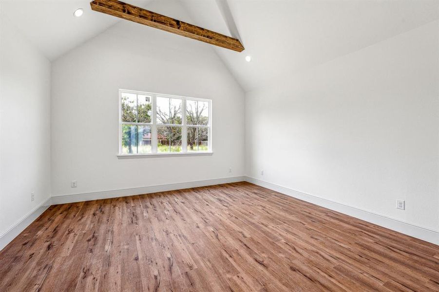 Unfurnished room with light hardwood / wood-style floors, high vaulted ceiling, and beamed ceiling